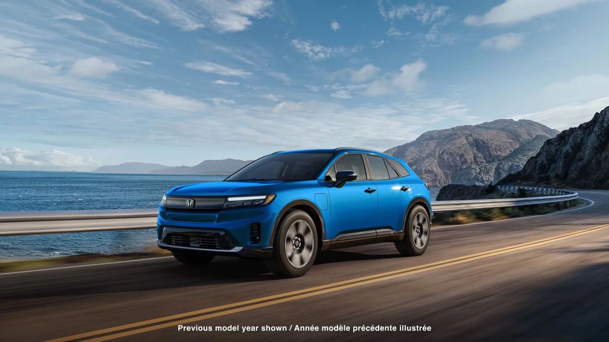 Honda Prologue 2025 bleu roulant sur une route côtière, mettant en valeur son design moderne et son autonomie efficace.