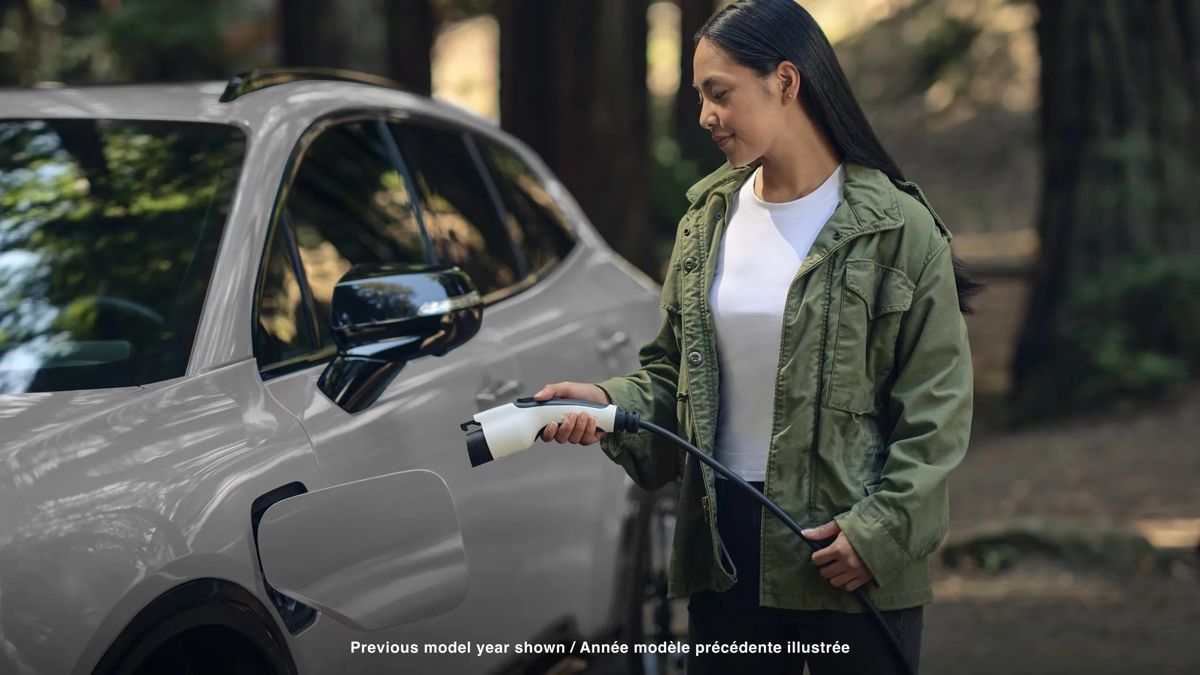 Femme branchant son Honda Prologue 2025 argenté sur une borne de recharge, symbolisant la simplicité et la commodité de la recharge électrique.