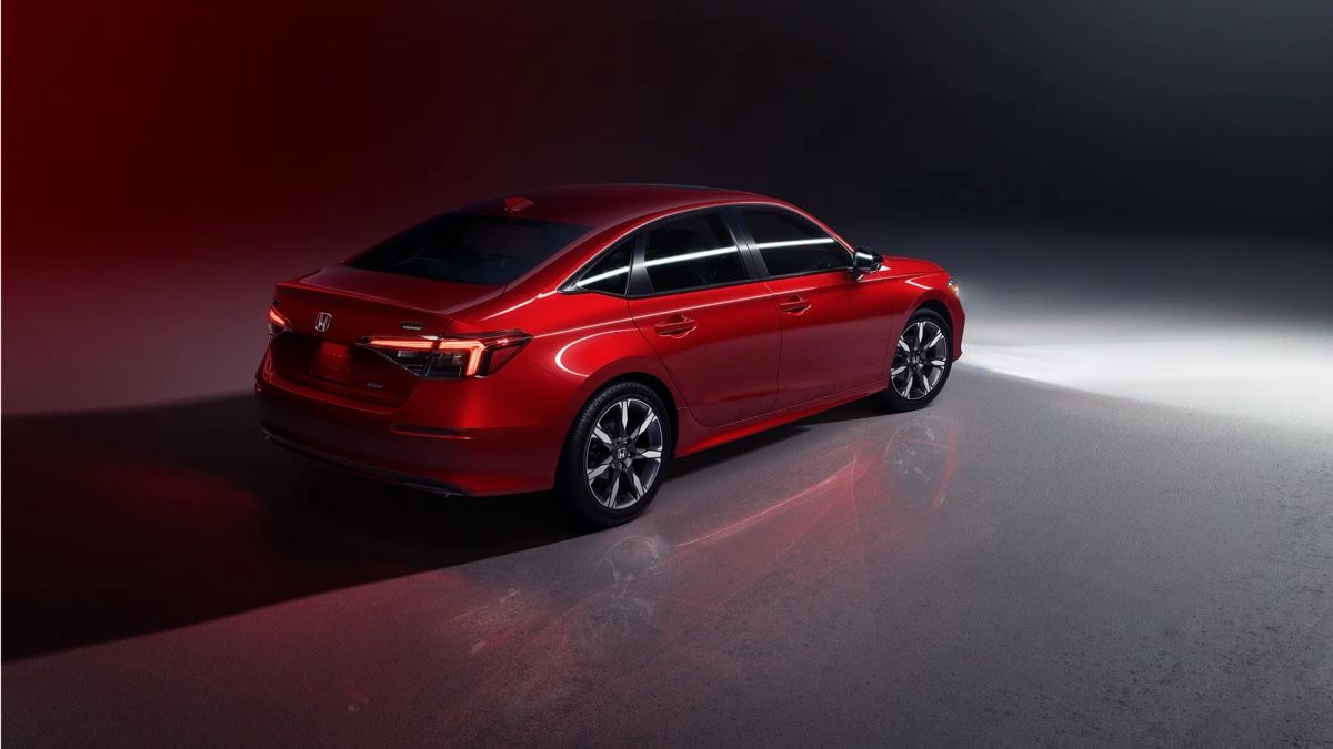 Honda Civic 2025 rouge vue arrière trois quarts dans un studio sombre, soulignant son style élégant et sportif.