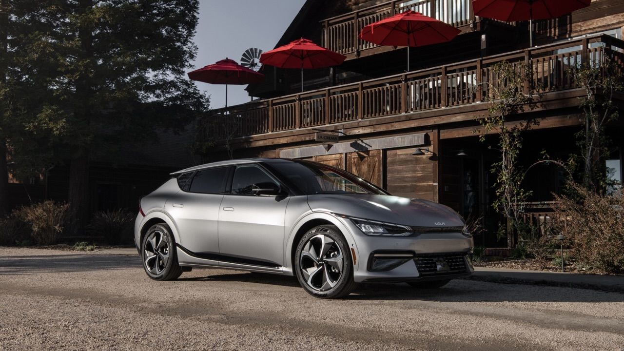 La Kia EV6 stationné sur la gravel devant un chalet.