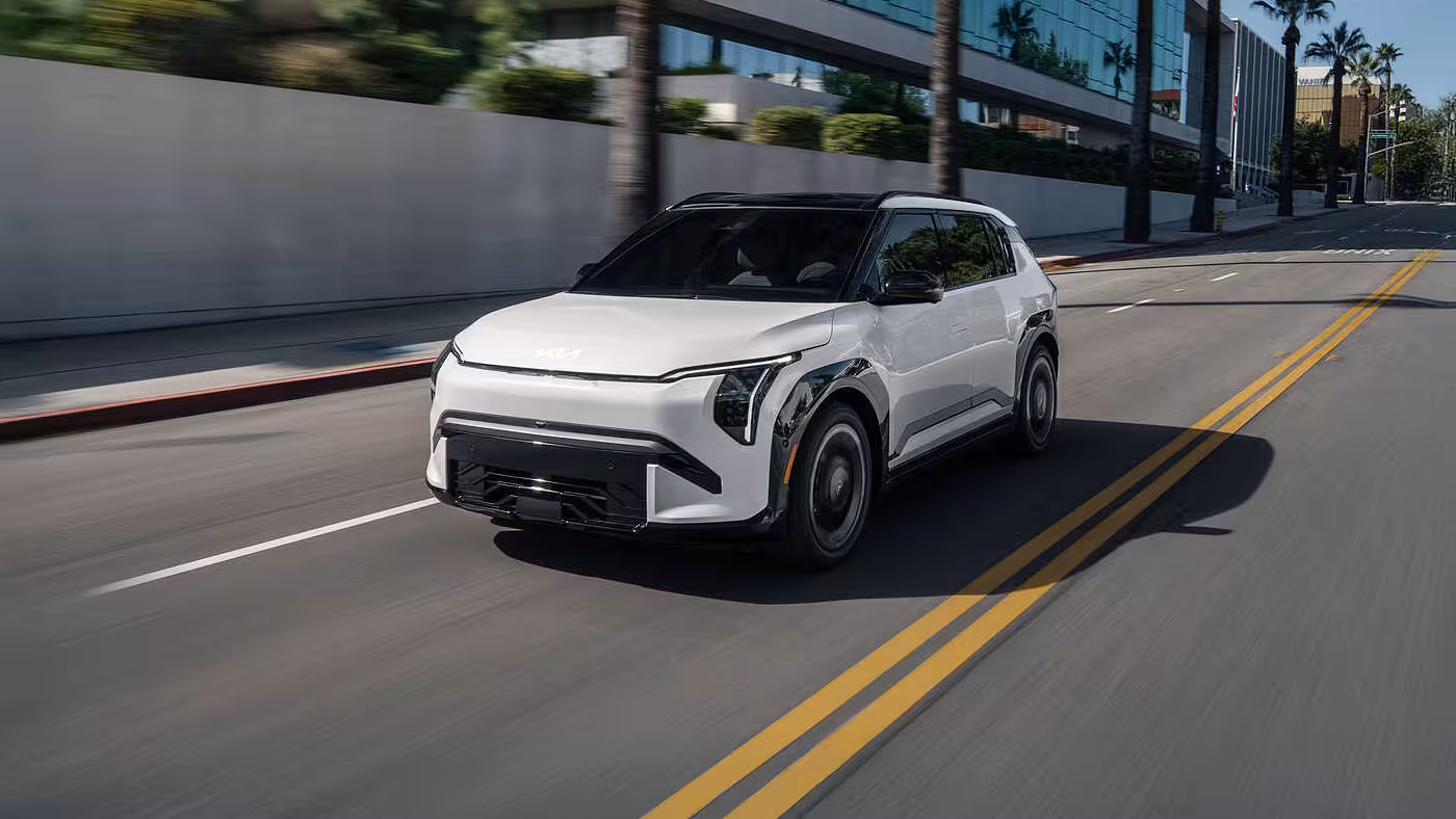 Kia EV3 2027 blanc roulant en milieu urbain, vu de trois quarts avant