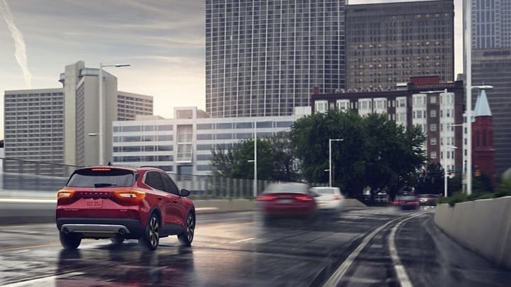 Vue 3/4 arrière du Ford Escape 2024 arrivant en ville par l'autoroute.