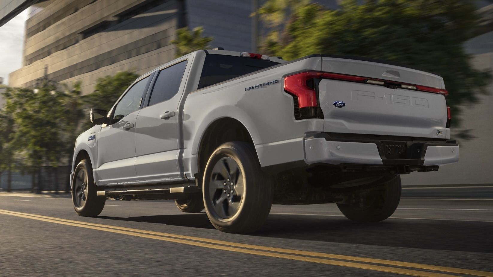 Vue 3/4 arrière du Ford F-150 Lightning qui roule en ville.