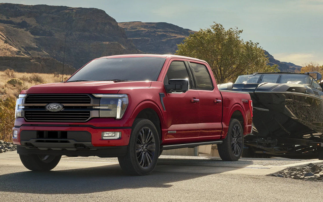 image entête - vue latérale avant d'un Ford F-150 trainant un bateau sur une rampe d'accès près d'un lac