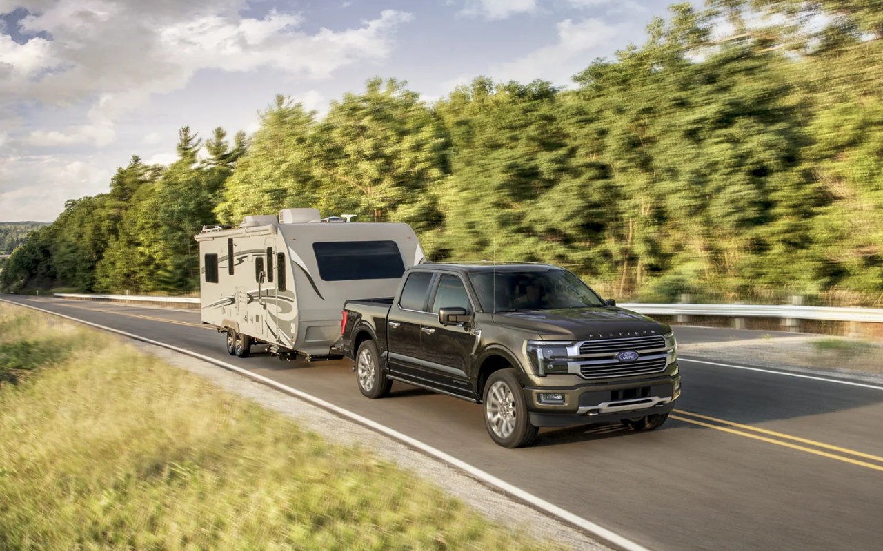 vue latérale avant d'un Ford F-150 trainant une roulotte sur une route de campagne