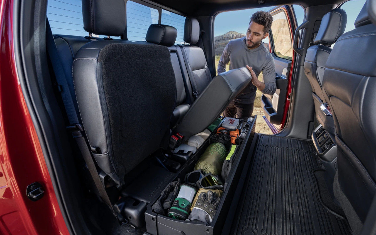 vue d'un homme qui compresse les bancs arrière d'un Ford F150 pour libérer de l'espace