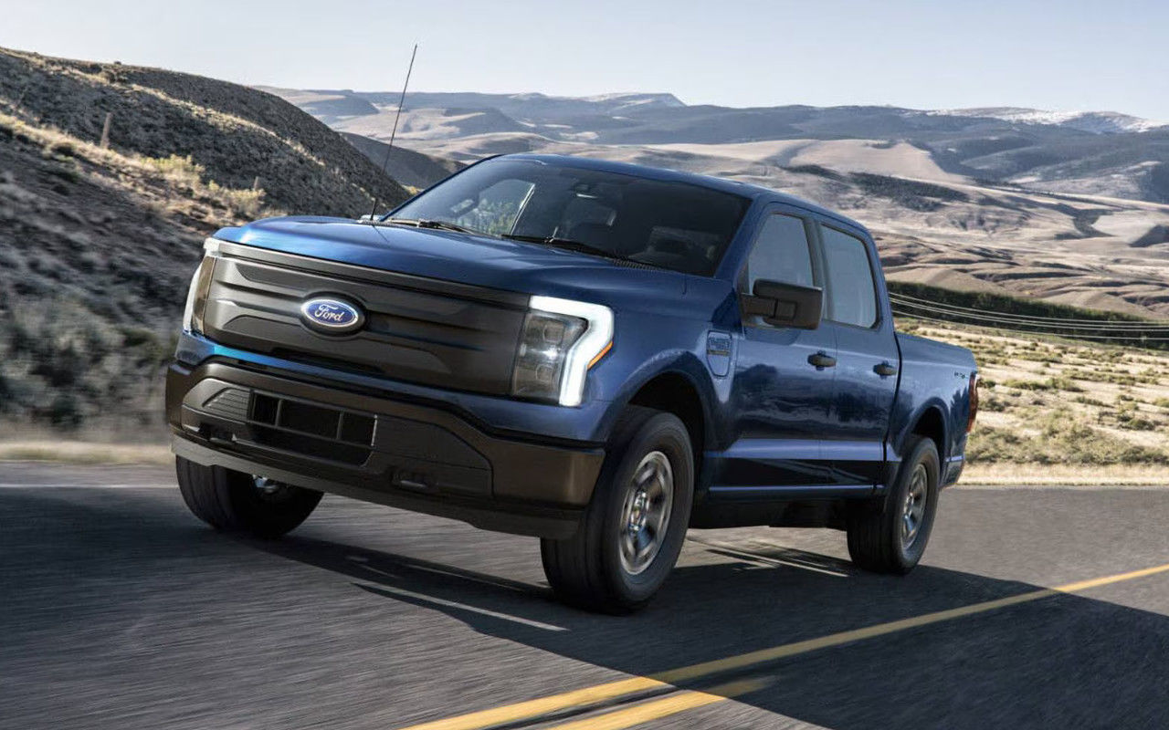 image entête - vue latérale avant d'un Ford F150 lightning sur une route de montagne