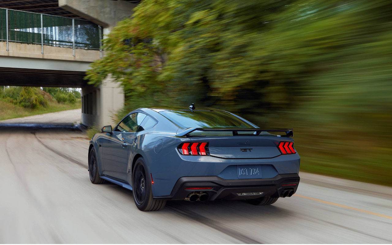 vue latérale arrière d'un Ford Mustang 2025 sur une route de campagne