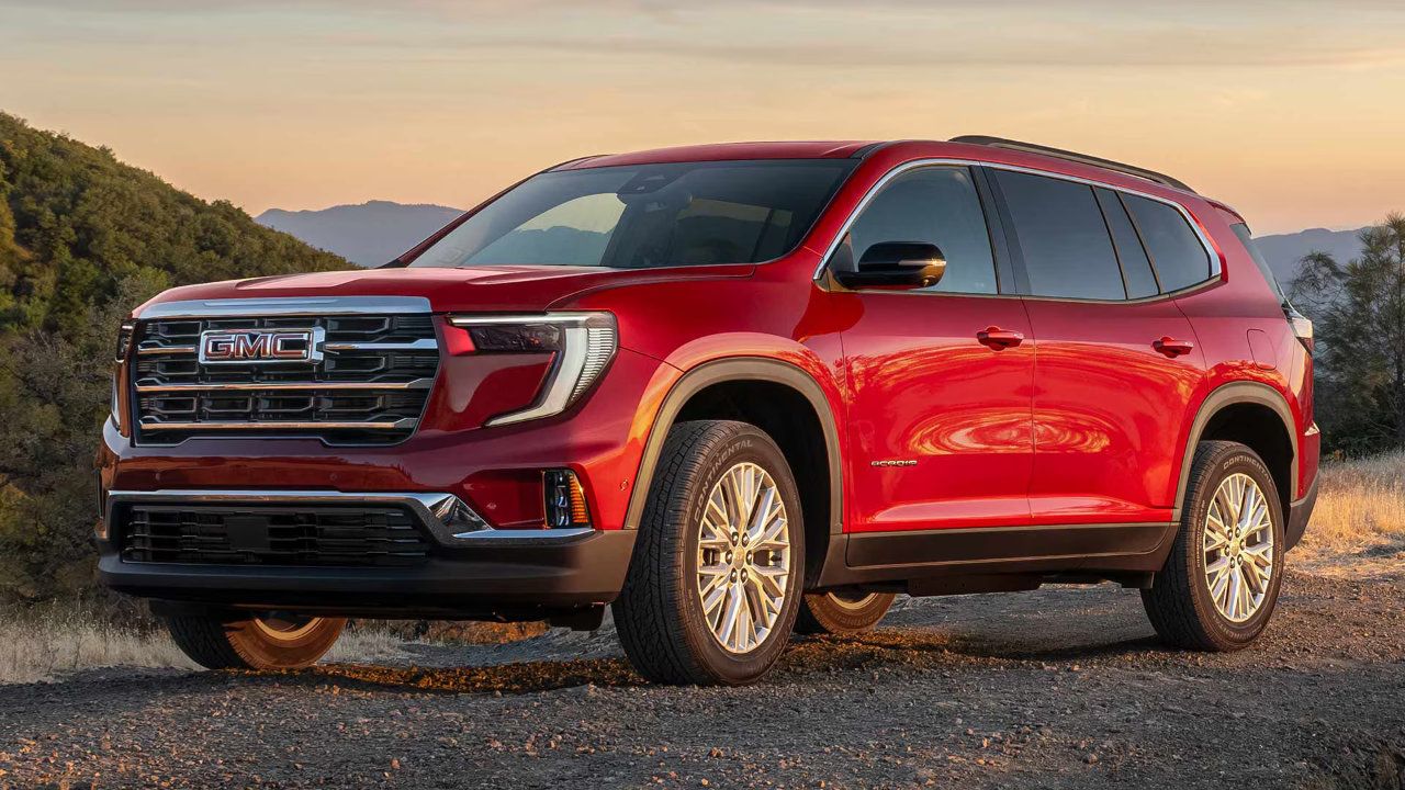 Vue avant dynamique du nouveau GMC Acadia 2026 rouge sur un sentier