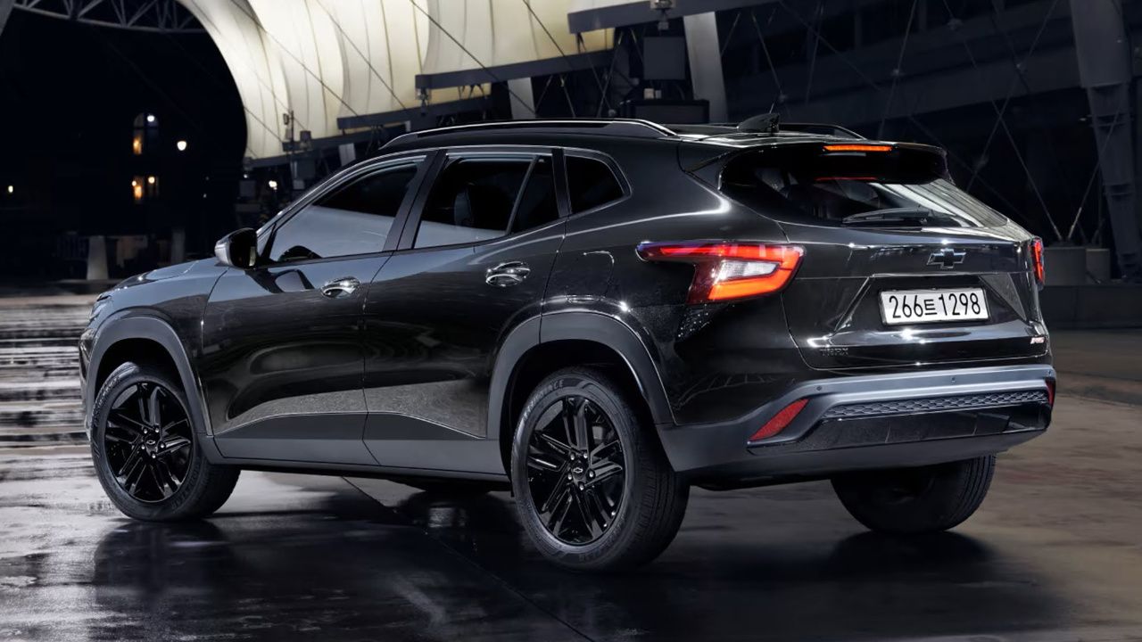 Rear three-quarter view of the 2026 Chevrolet Trax driving on a country road