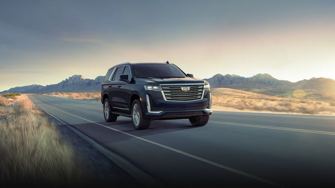 Cadillac Escalade 2024 on the road at sunrise.