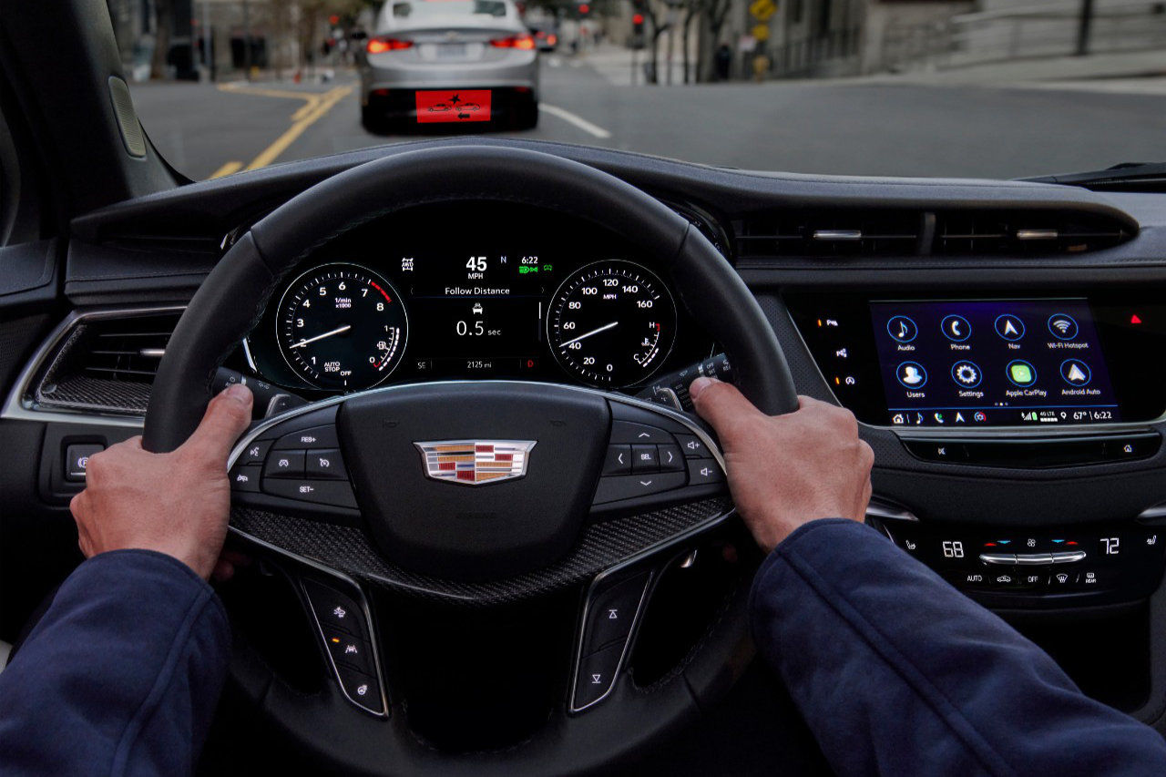 Hands driving the 2023 Cadillac XT5 including head-up display.