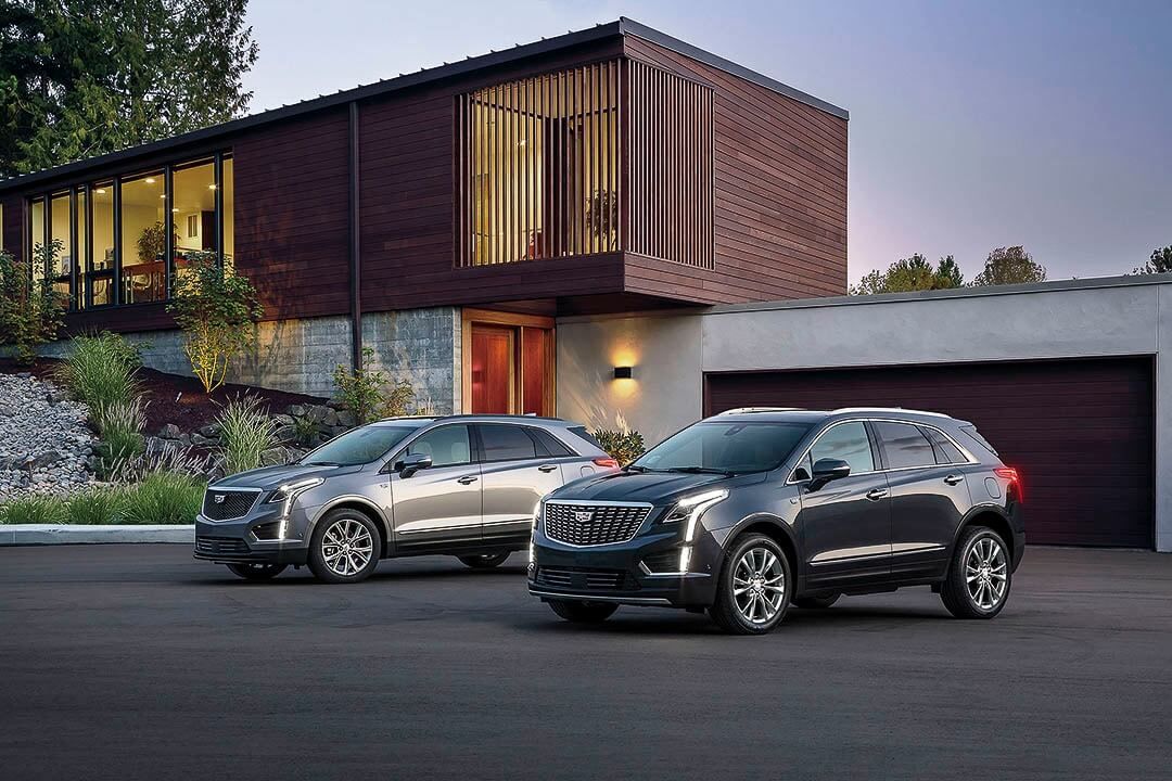 two 2022 Cadillac XT5 parked in front of a house