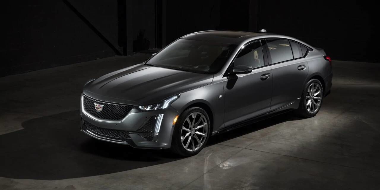 Cadillac CT5 2020, design gris, à l'intérieur d'une pièce sombre avec un reflet de lumière subtile plombant sur le véhicule