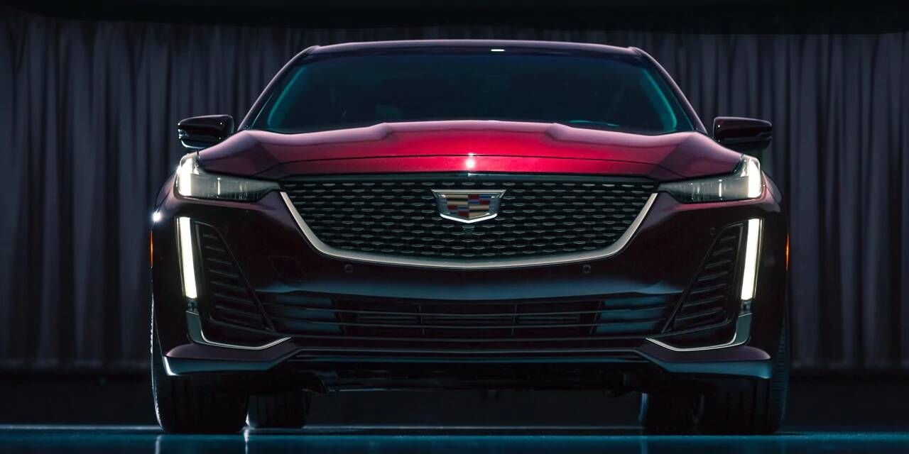 l'avant du Cadillac CT5 2020, design rouge, rideau rouge fermé en arrière-plan