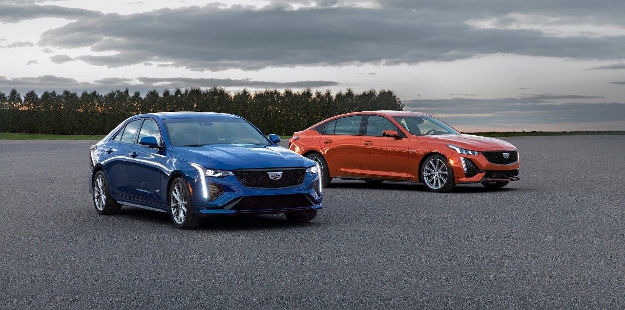 Blue 2020 Cadillac CT4-V on the left and the orange 2020 Cadillac CT5-V on the right, both vehicles parked outside