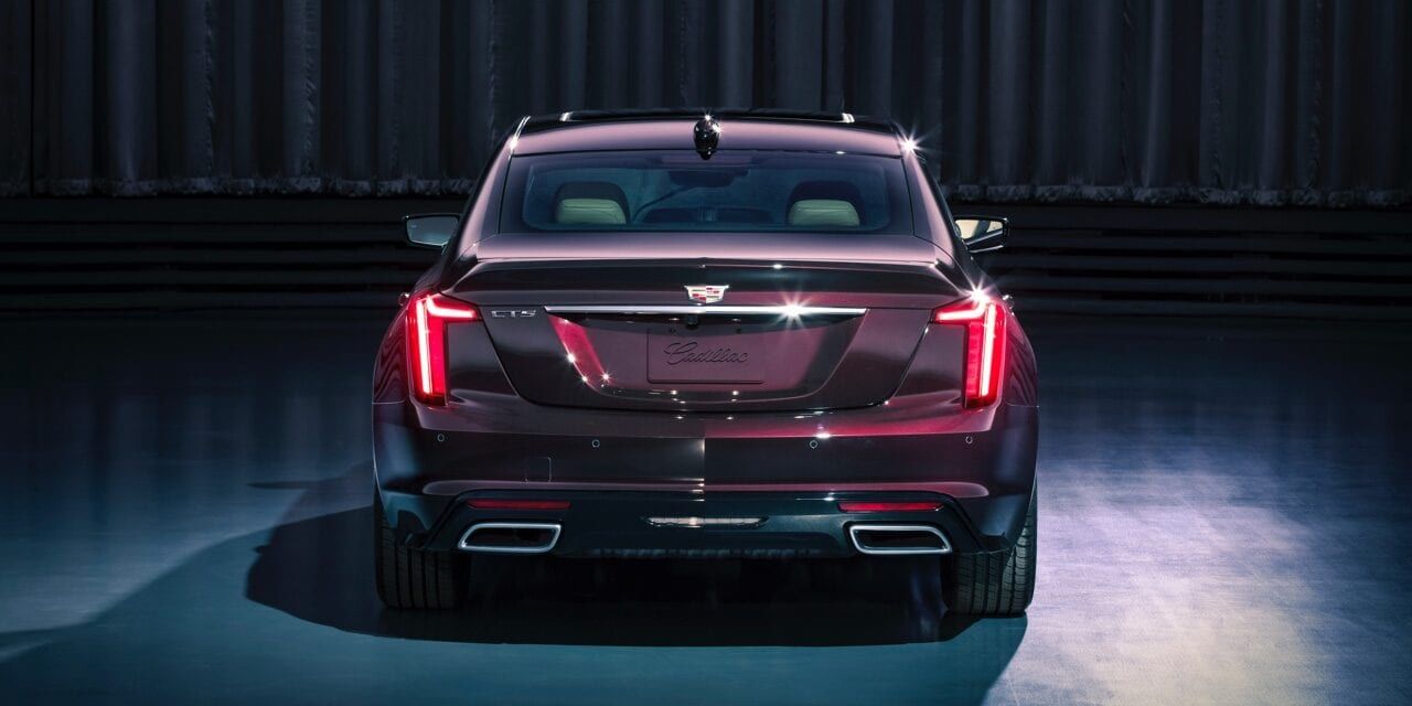 rear view of the red 2020 Cadillac CT5 in a showroom with its taillights on