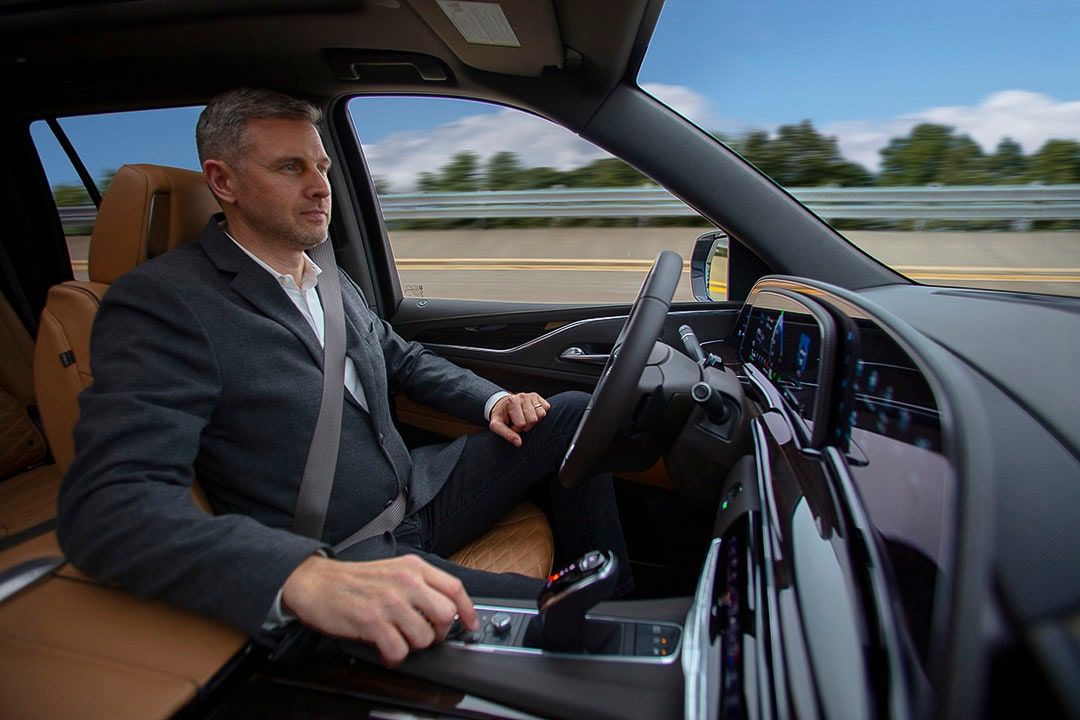 vue intérieure du Cadillac Escalade 2021 avec un homme au volant utilisant la fonction mains libres Super Cruise