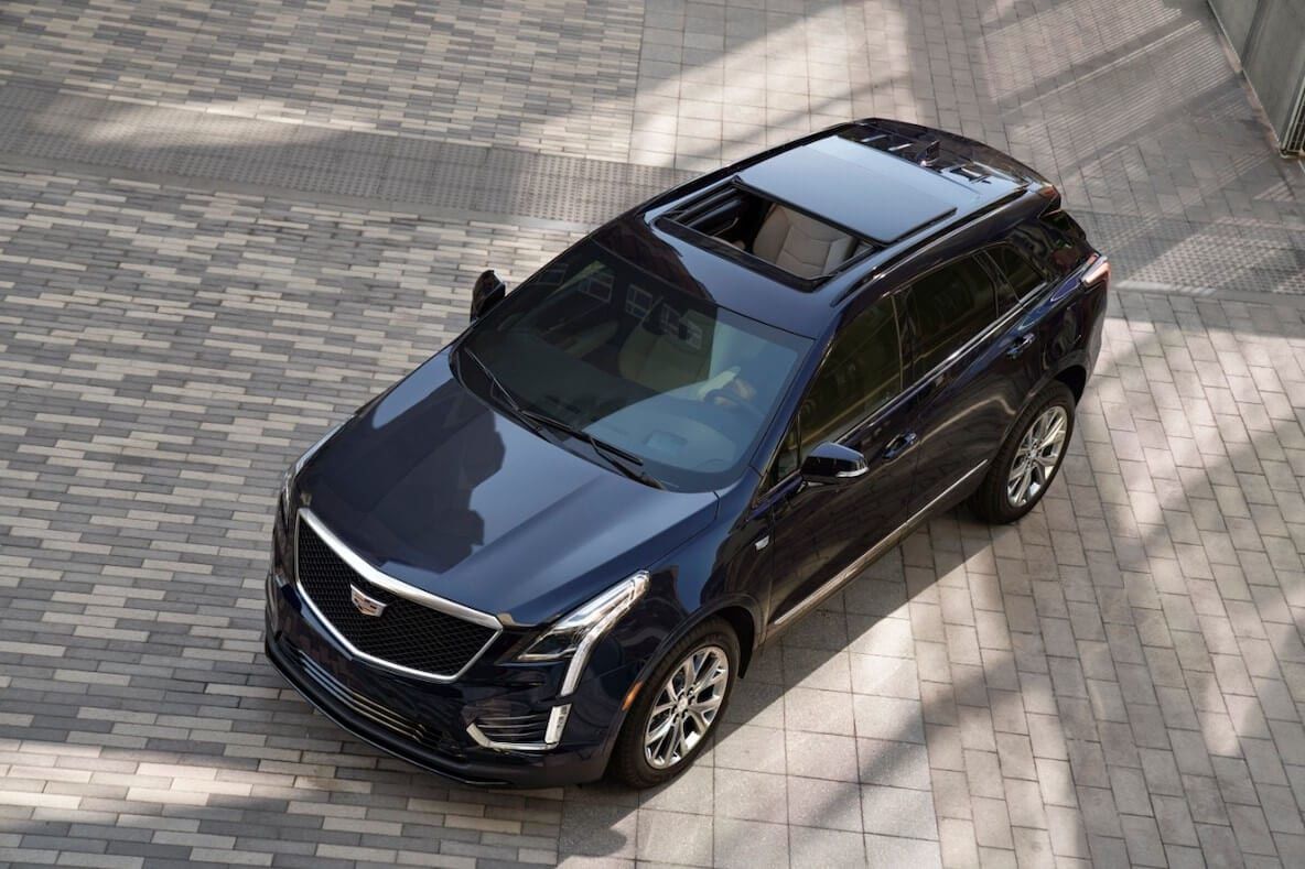 The open sunroof of the black 2021 Cadillac XT5 parked on a paving stone