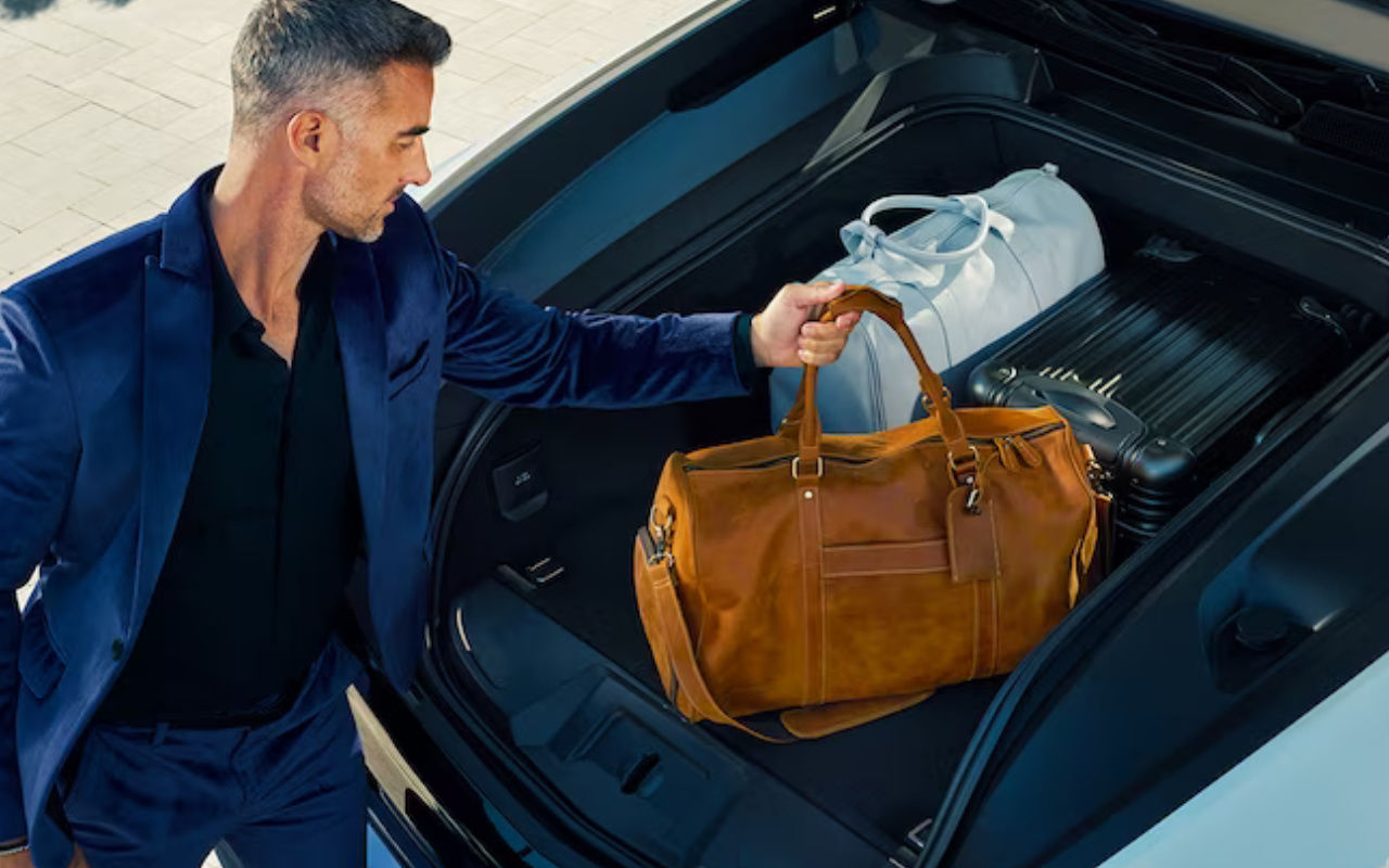 vue d'un homme en train de de charger l'arrière de sa Cadillac Escalade IQ 2024 avec des sacs