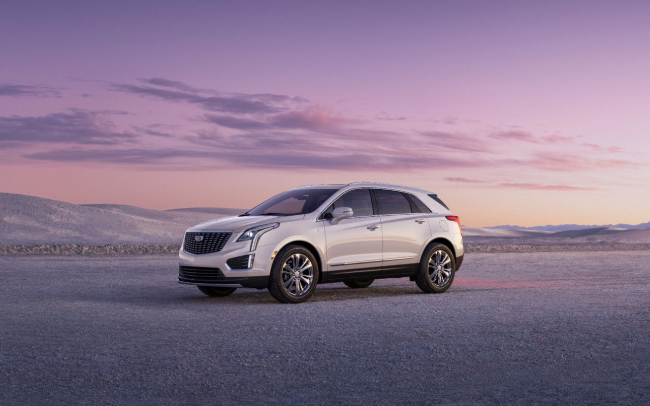 front side view of a 2024 Cadillac XT5 in the desert at dusk