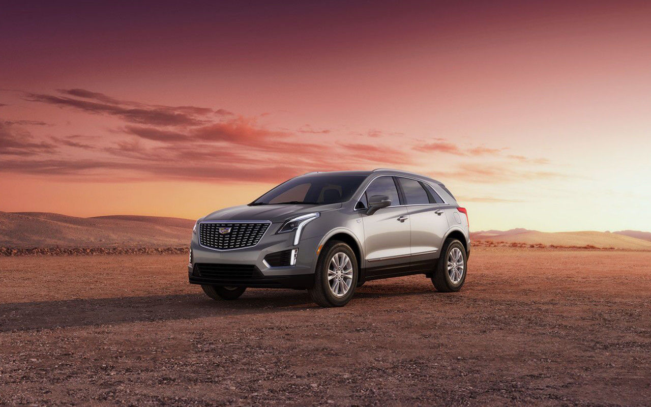 front side view of a 2024 Cadillac XT5 in the desert at dusk