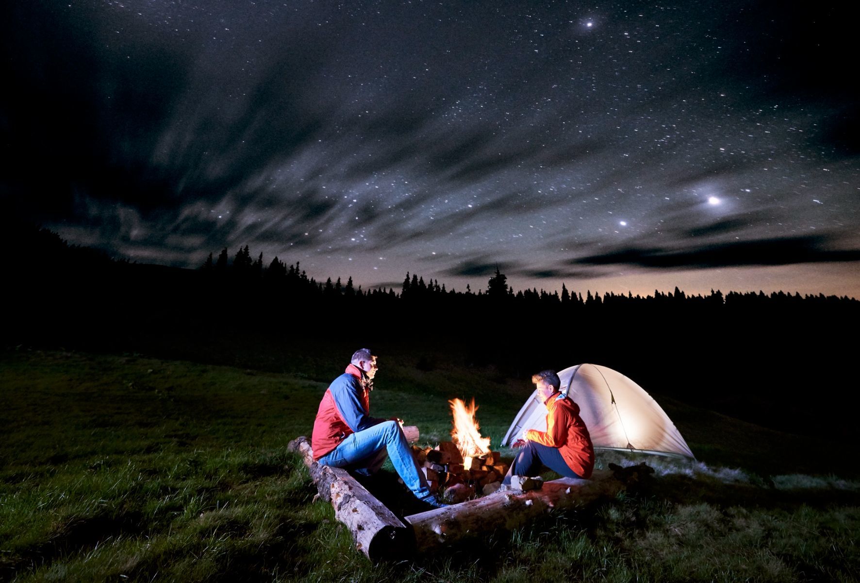 Un couple en camping qui observe les étoiles.