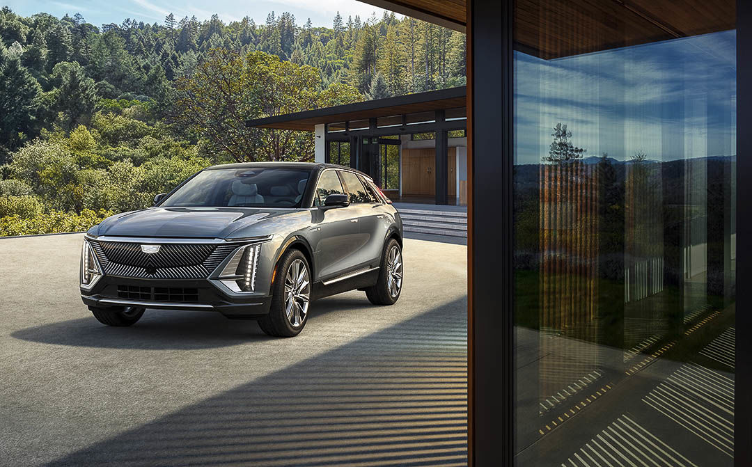 Un Cadillac Lyriq stationné devant une résidence.