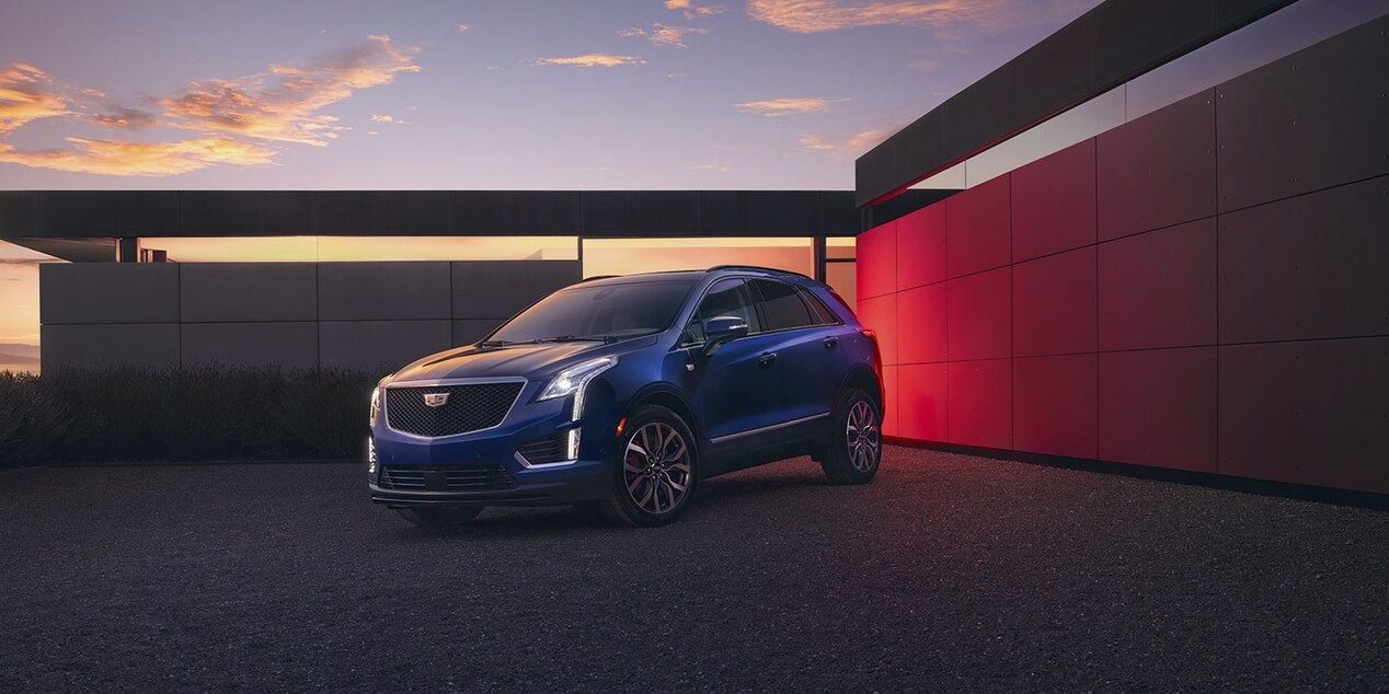 Front 3/4 view of Cadillac XT5 parked in front of a residence.