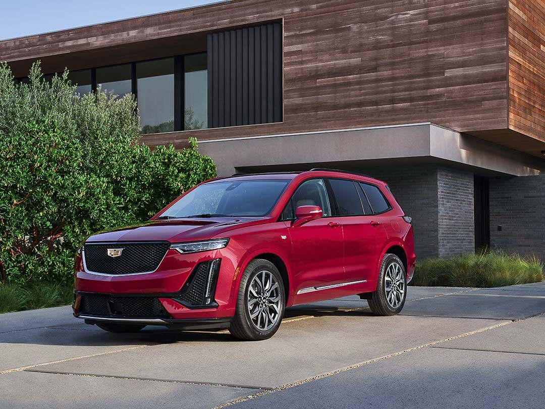 A Cadillac XT6 parked in front of a residence.