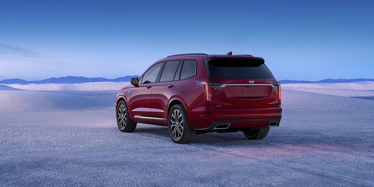 The Cadillac XT6 parked for the night under an aurora borealis backdrop.