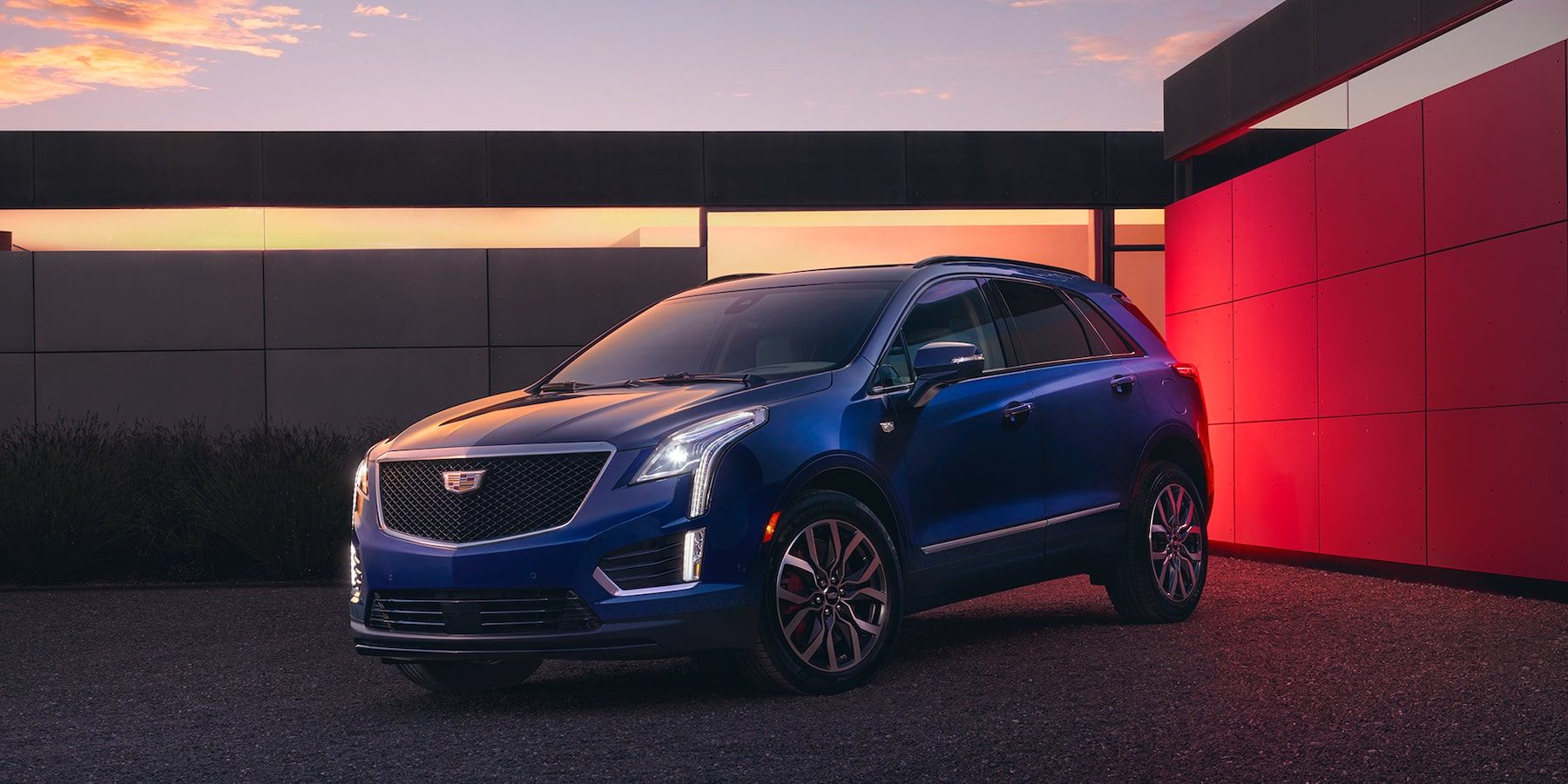 3/4 front view of the 2025 Cadillac XT5 with its imposing grille, parked outside.