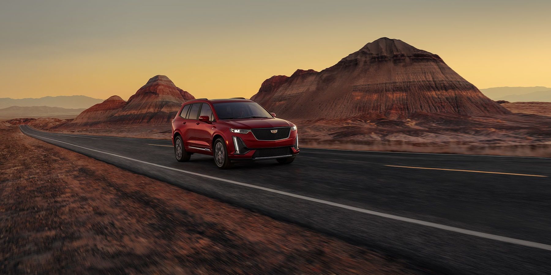 3/4 front view of 2025 Cadillac XT6 driving on a desert road.