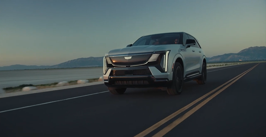 Front 3/4 view of the 2026 Cadillac VISTIQ driving on a road.