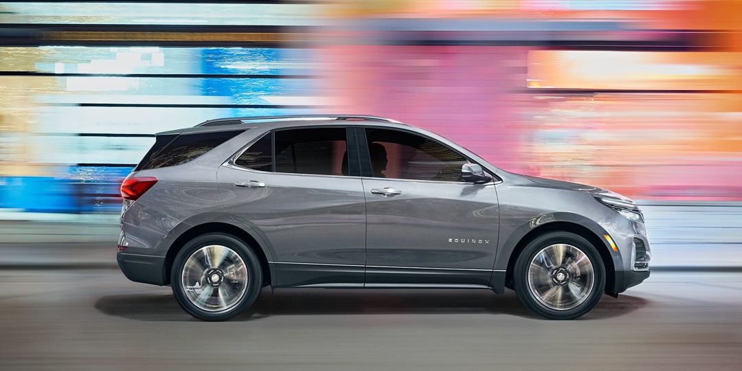 Vue latérale du Chevrolet Equinox 2023 roulant en puissance sur une route.