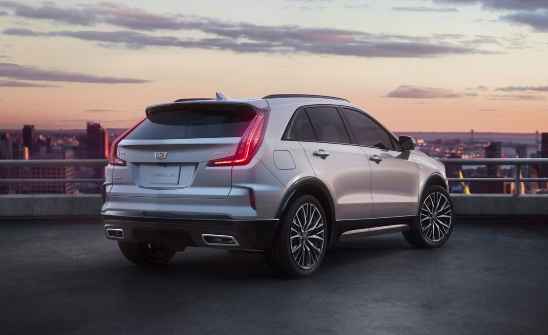 rear side view of a 2024 Cadillac XT4 on a building's roof at dusk