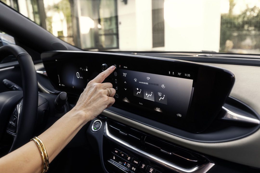 Conducteur au volant du Buick Envista 2024 changeant les réglages du Apple CarPlay.