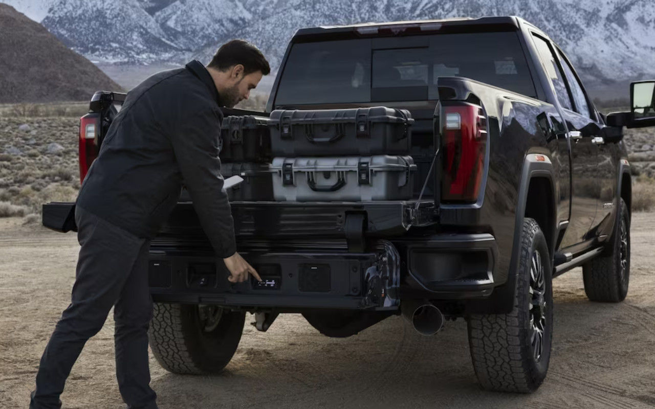 vue d'un homme qui charge l'arrière d'un GMC Sierra 2500 2024