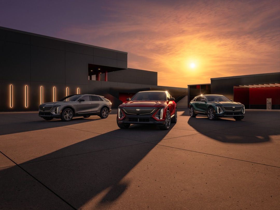 vue d'un trio de Cadillac Lyriq 2024 devant un bâtiment moderne au crépuscule