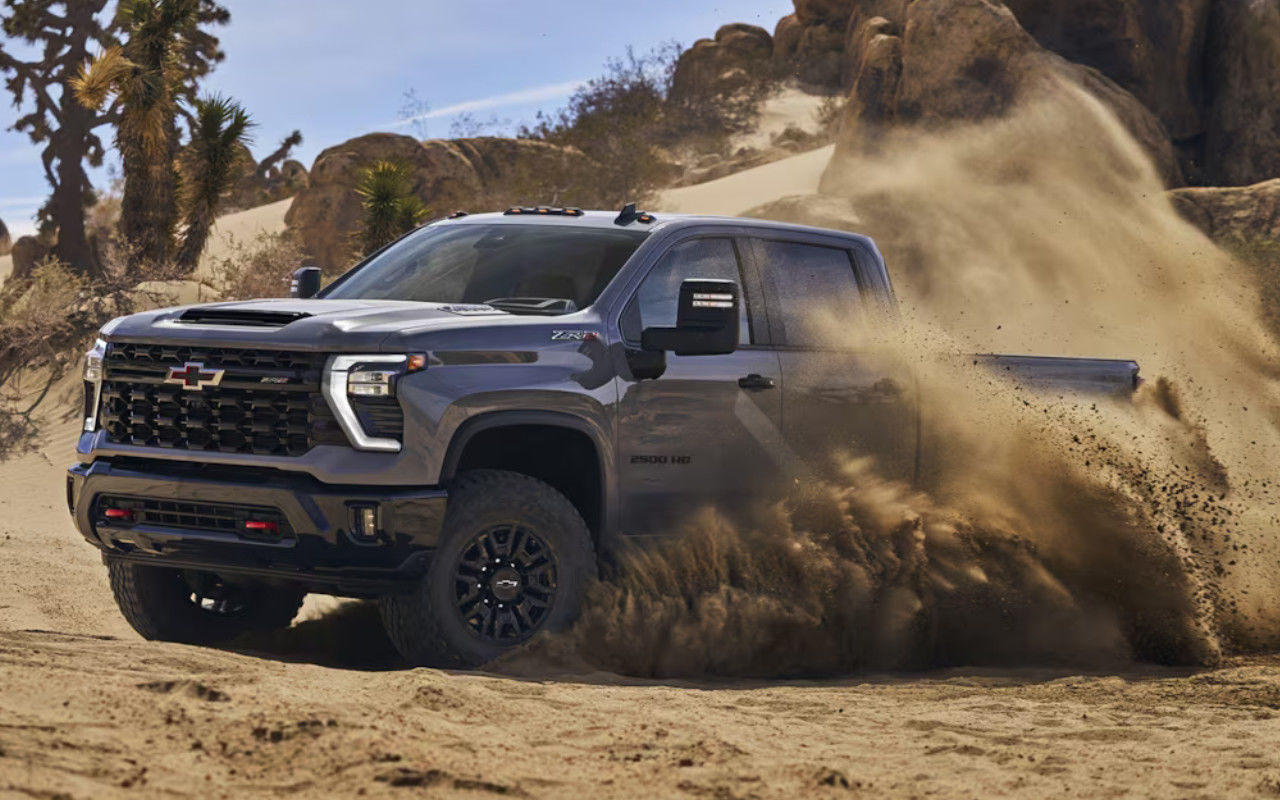 vue latérale avant d'une Chevrolet Silverado 2500 HD 2024 effectuant un tournant serré dans le sable