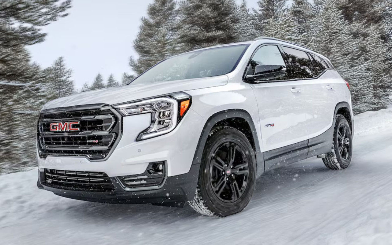 vue latérale avant d'un GMC Terrain Denali 2024 sur une route de montagne enneigée