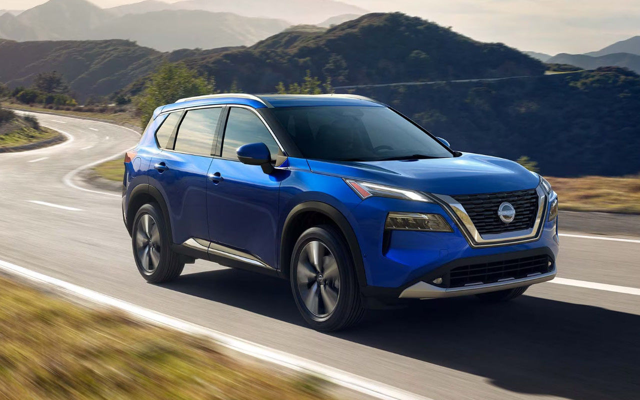 vue latérale avant d'une Nissan Rogue 2024 sur une route en montagne