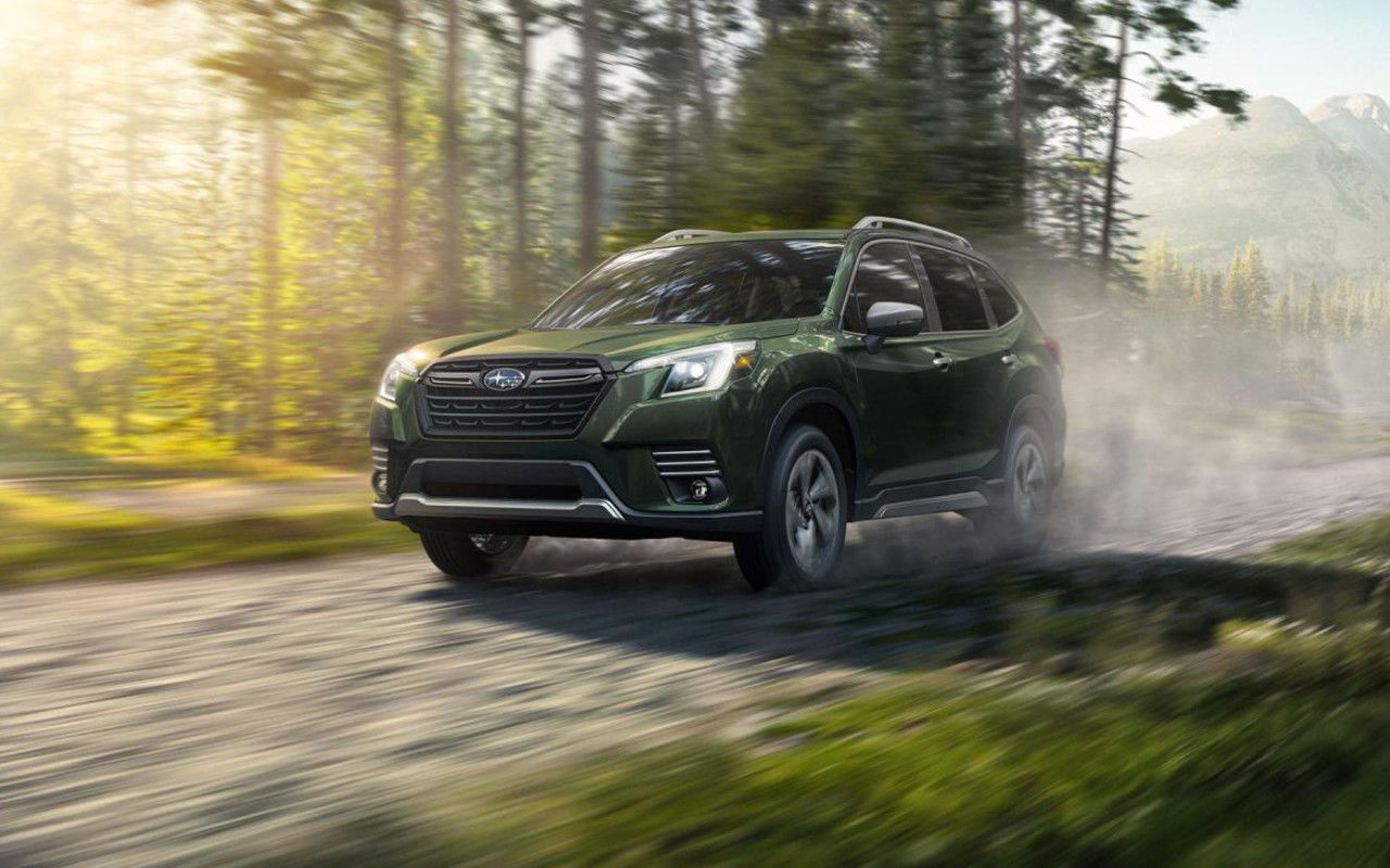 vue latérale avant d'une Subaru Forester 2024 sur une route en forêt