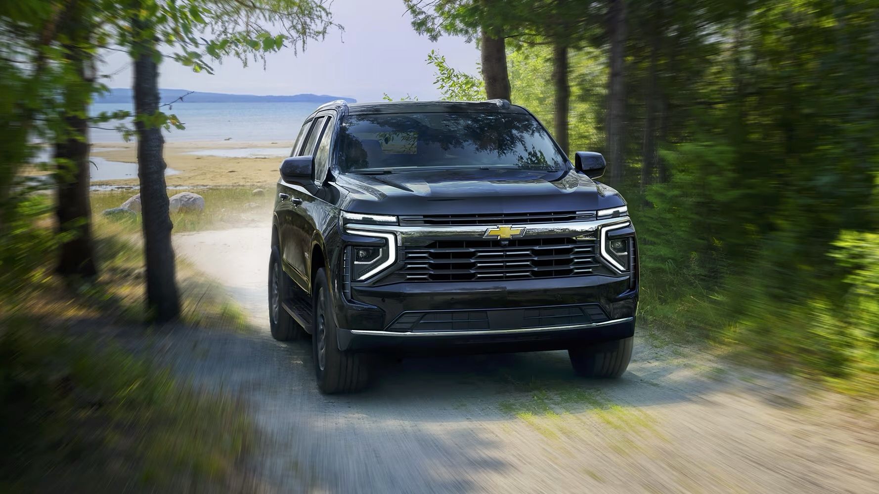 Le Chevrolet Tahoe 2025 démontre toute sa puissance sur un chemin de gravel dans les bois.