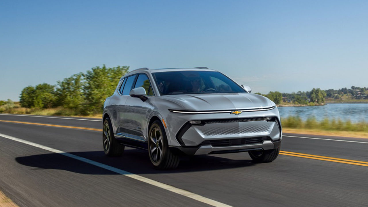 vue latérale avant d'un Chevrolet Equinox EV 2025 sur une route de campagne
