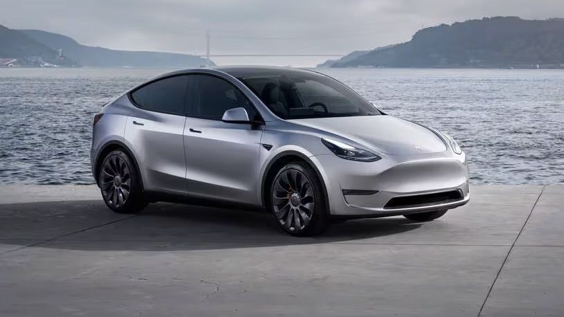 The Tesla Model Y parked at the water's edge.