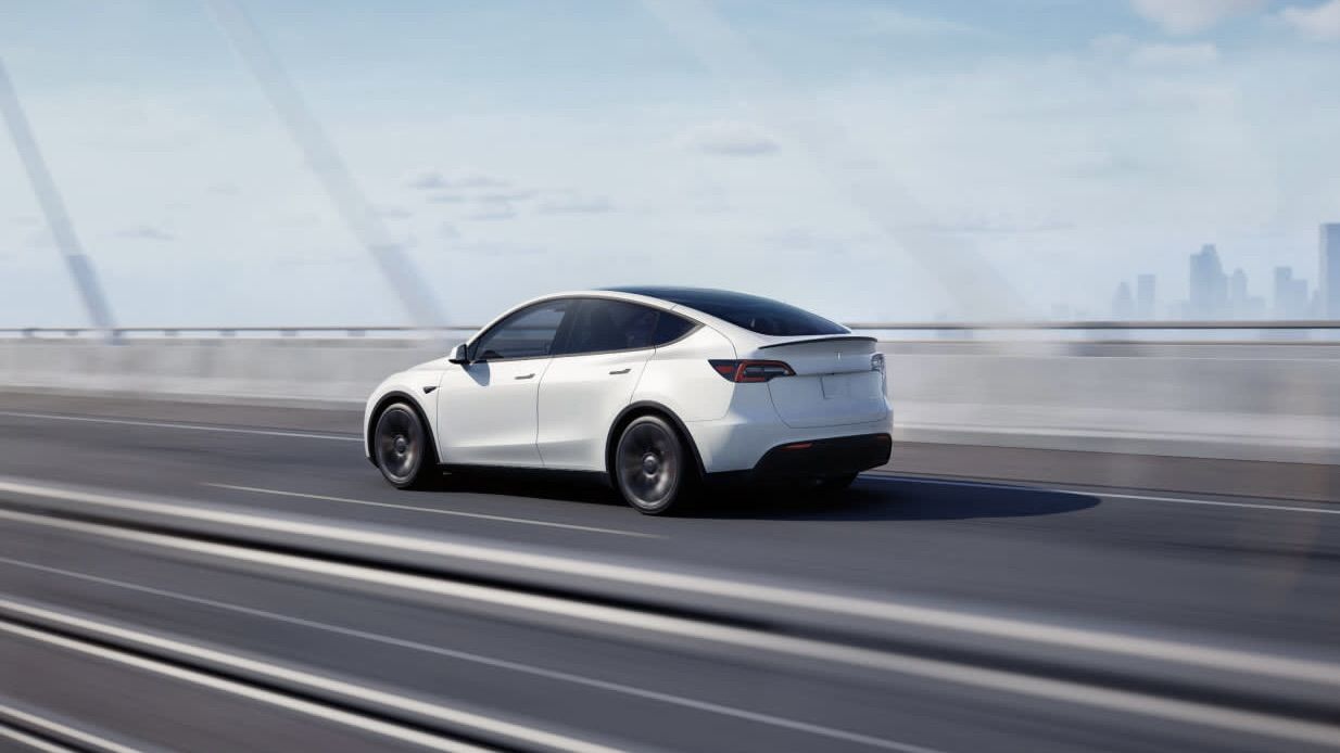 3/4 rear view of the Tesla Model Y on the road.