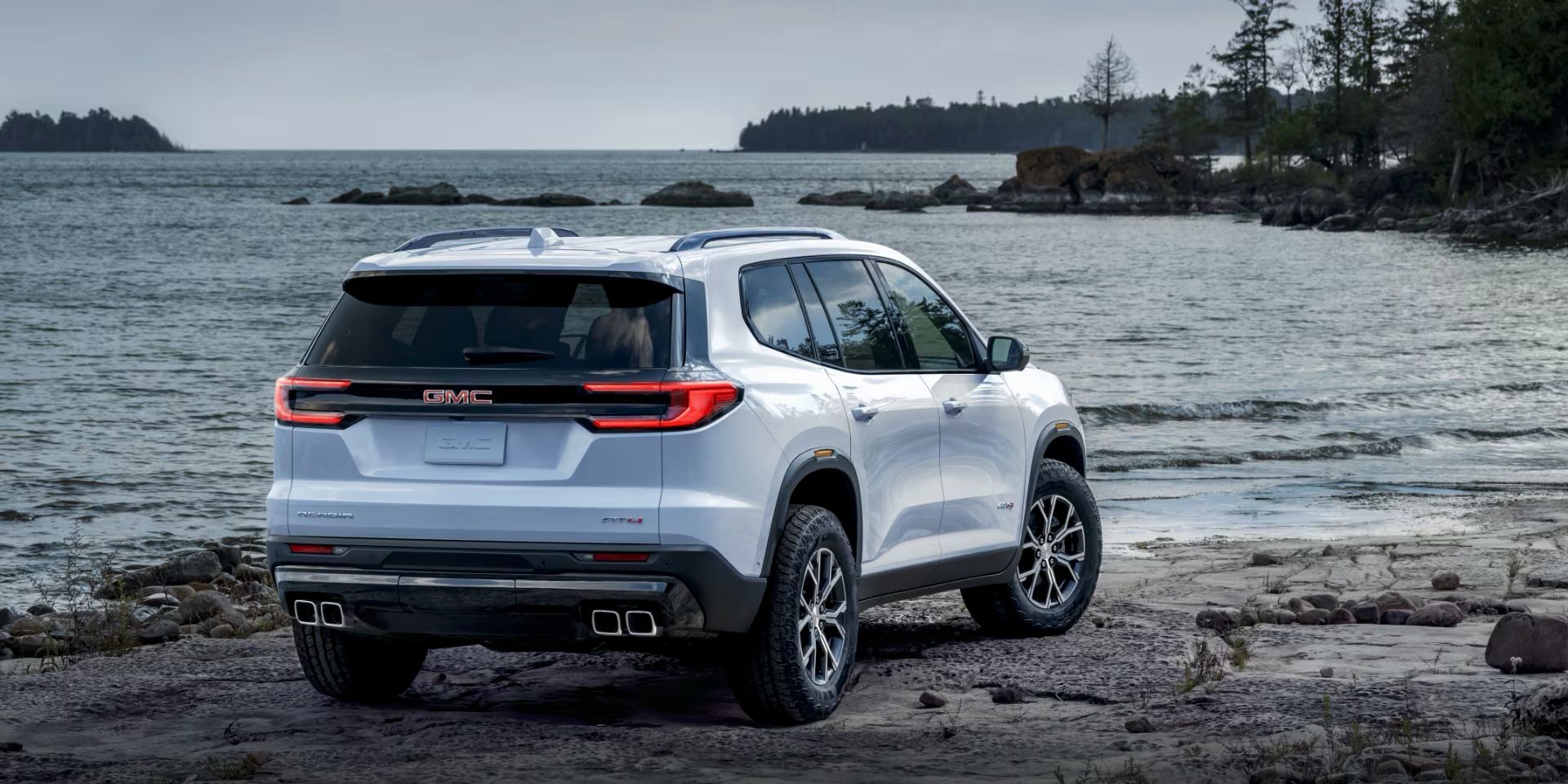 Le GMC Acadia 2024 vue de l'arrière stationné au bord de l'eau.