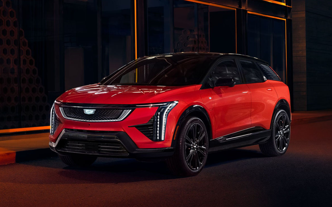 vue latérale avant d'une Cadillac Optiq 2025 garé devant un bâtiment la nuit.