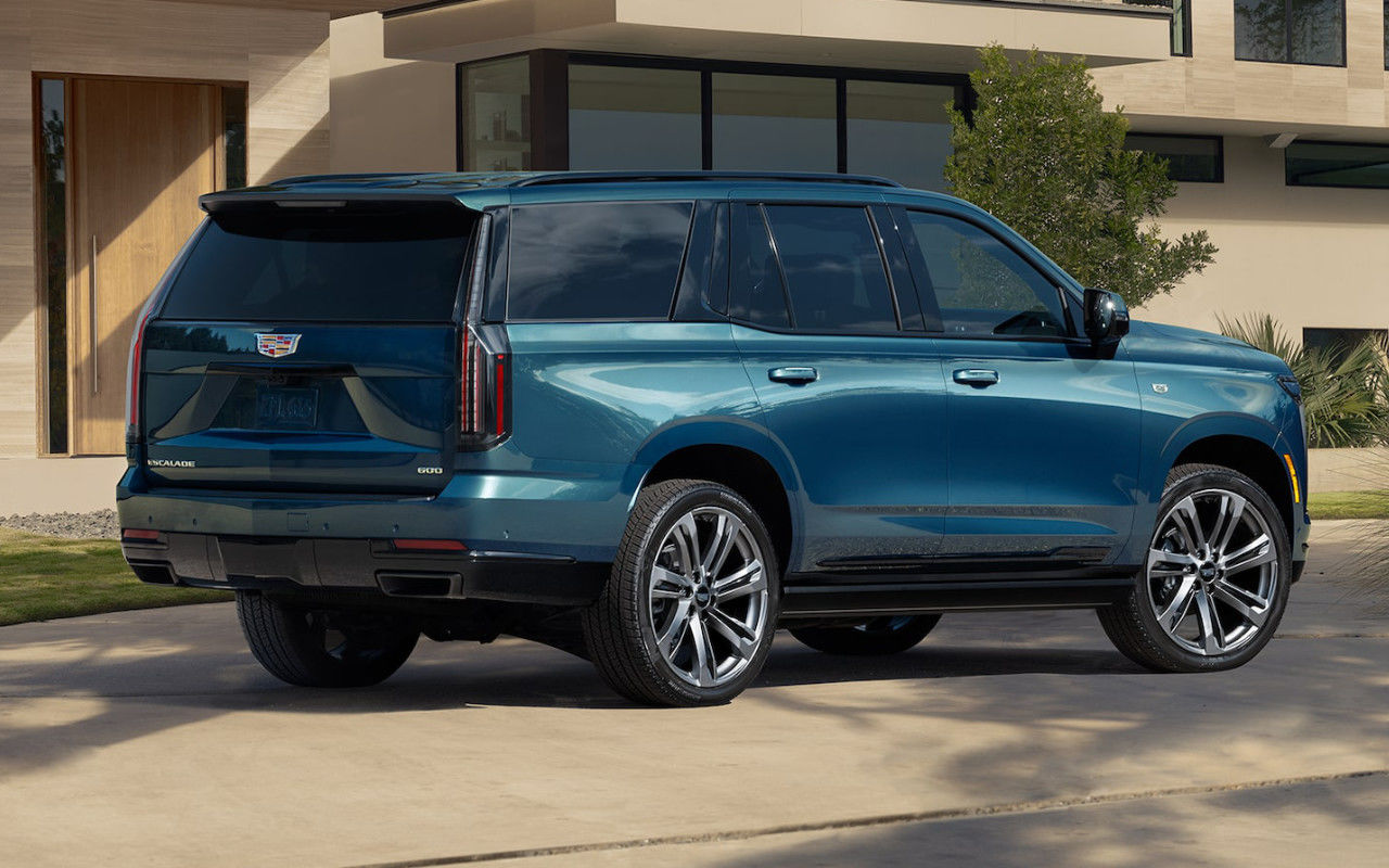 rear side view of a 2025 Cadillac Escalade parked in front of a house